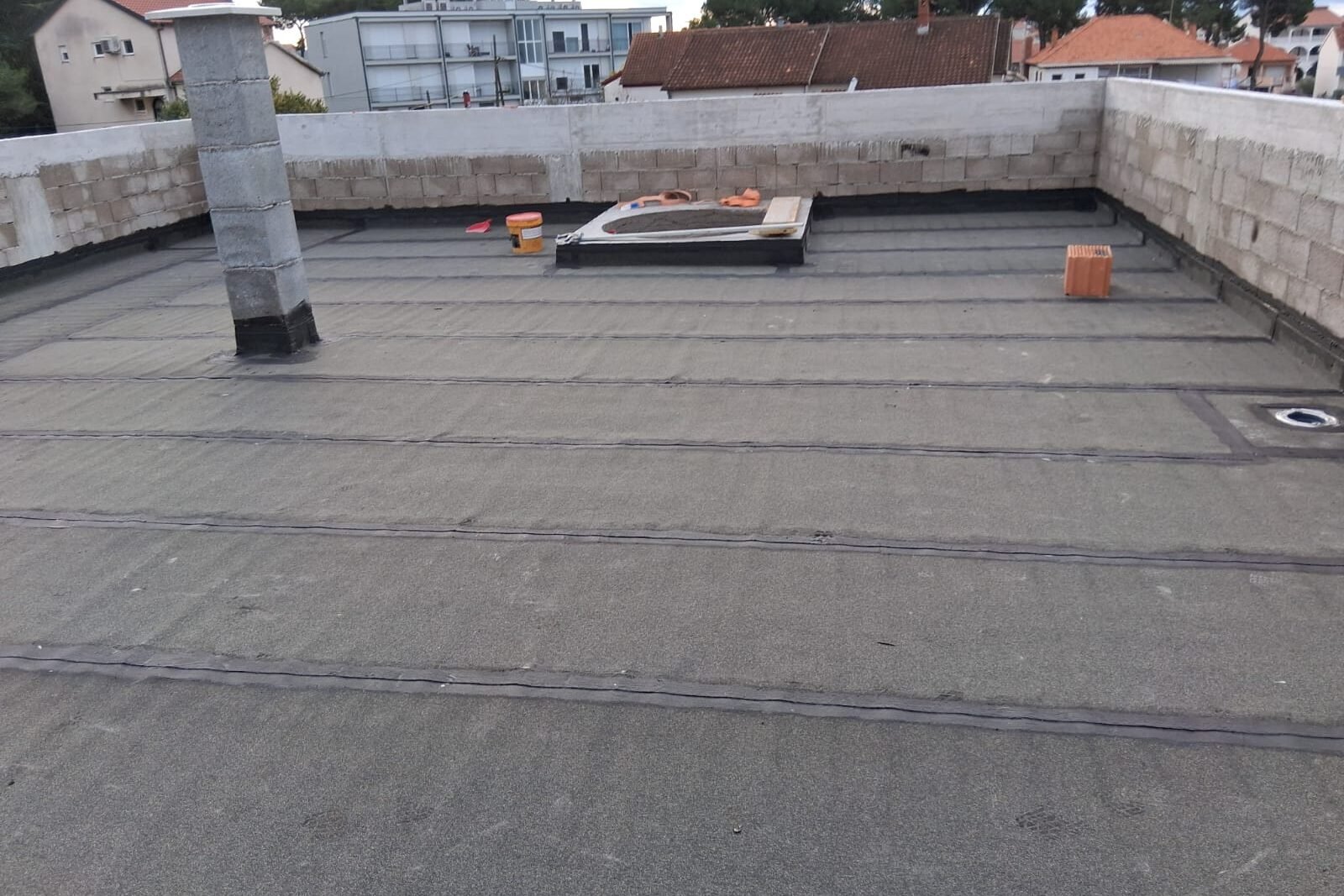 Ravni krov s položenom bitumenskom membranom, zidanim parapetom i krovnim slivnikom