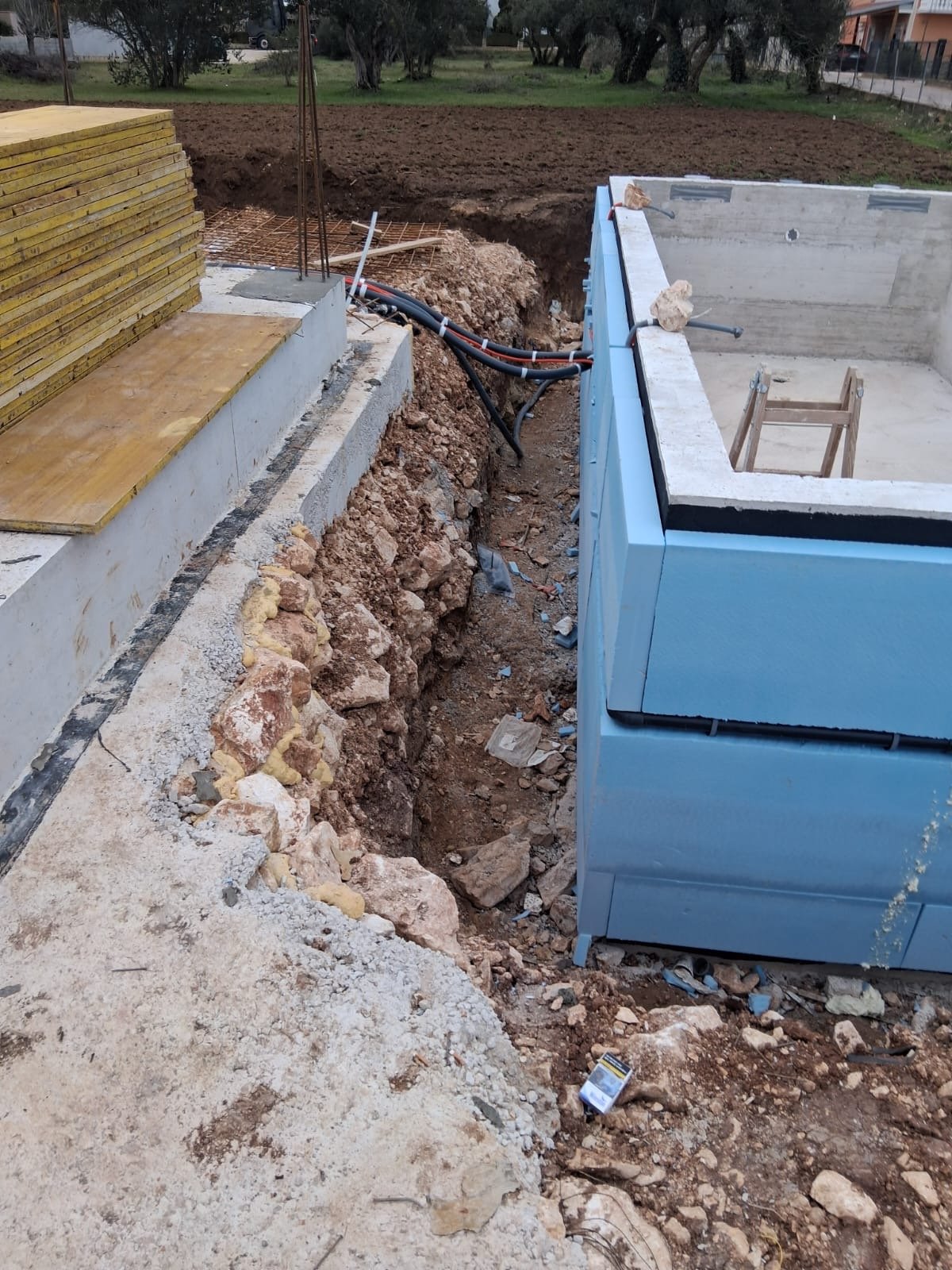 Vanjski betonski zid temelja obložen plavim zaštitnim pločama